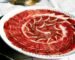 Jamón ibérico de bellota cortado a cuchillo y servido en plato en Bodegas del Desierto