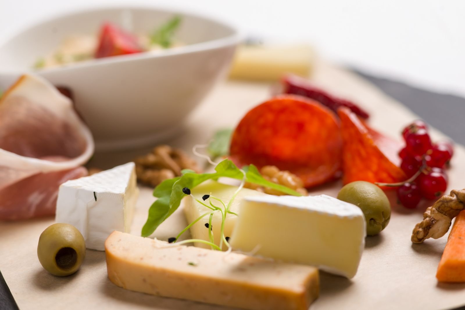 Tabla de madera con jamón, queso y picos presentados para un aperitivo gourmet
